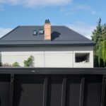 Black dumpster in front of house